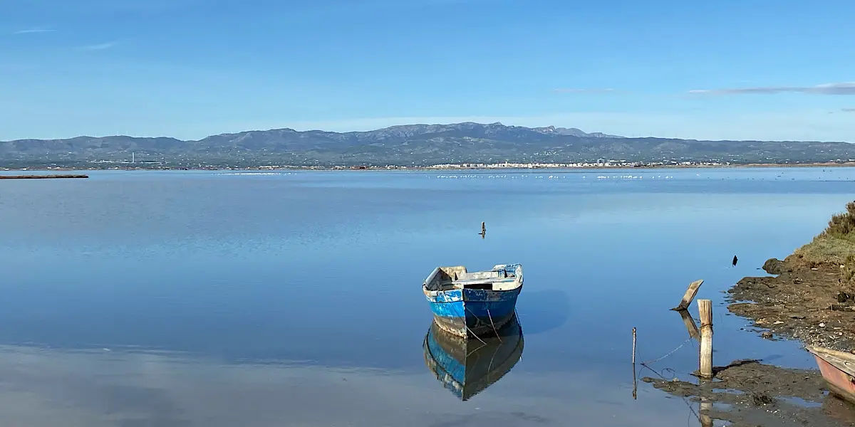 Barca de madera azul amarrada en las tranquilas aguas de una laguna en el Delta del Ebro