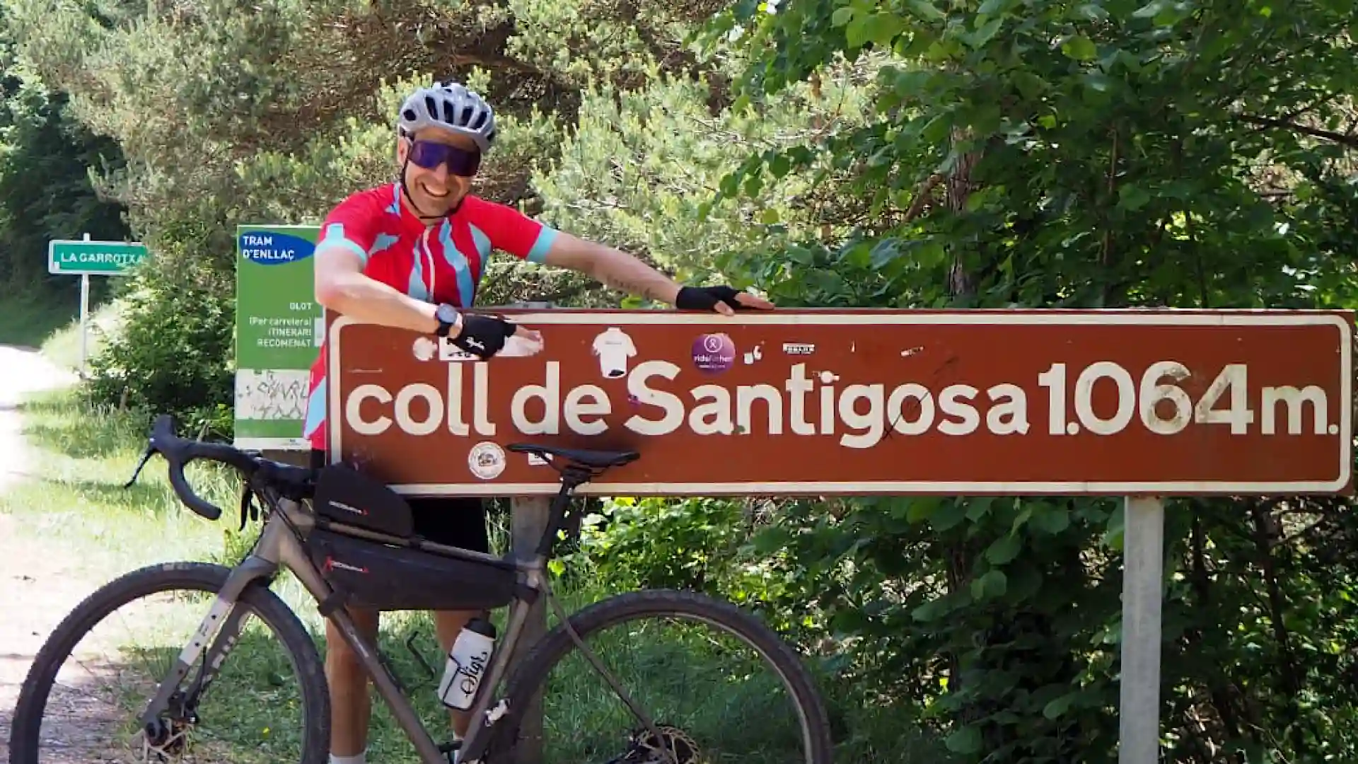 Alfonso posando con su gravel junto al cartel del puerto Coll de Santigosa cerca de Mas Guillamet. Casa Rural en el Ripollès